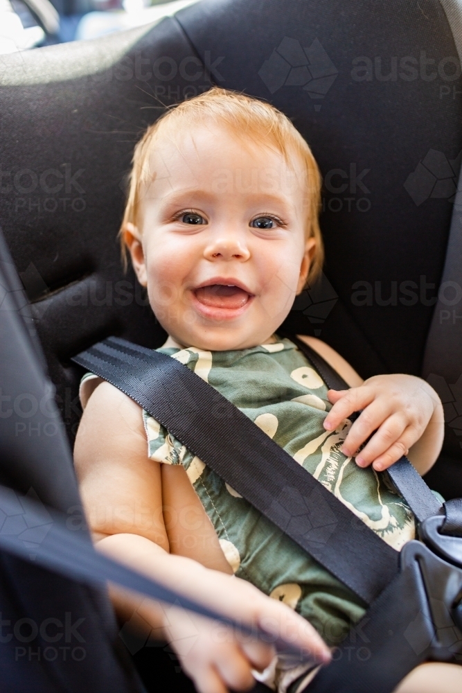 Image of happy Australian baby in rear facing car seat Austockphoto