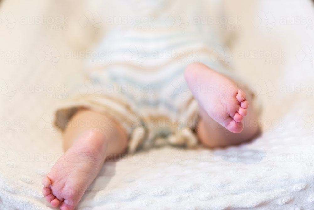Image of Happy baby feet kicking during tummy time on change table