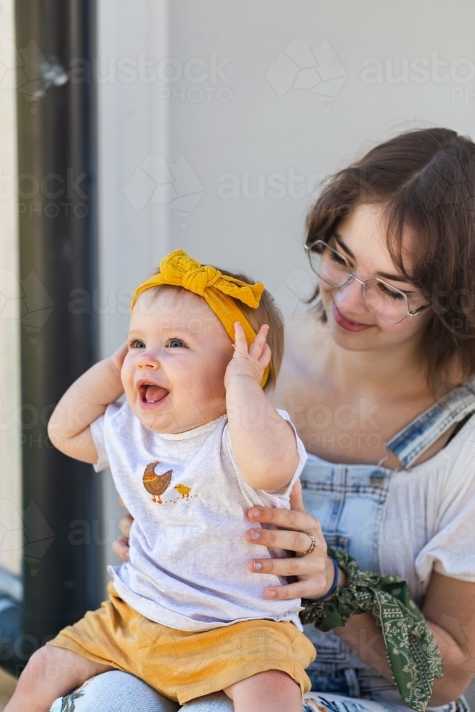 Image of happy baby girl sitting on her aunty