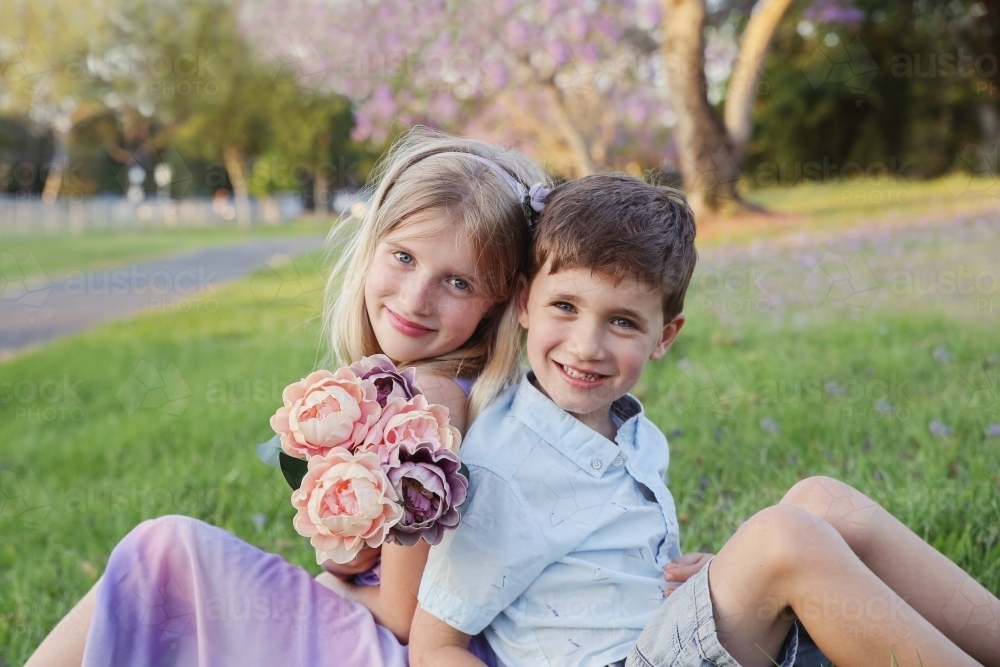 Happy brother and big sister in the park - Australian Stock Image