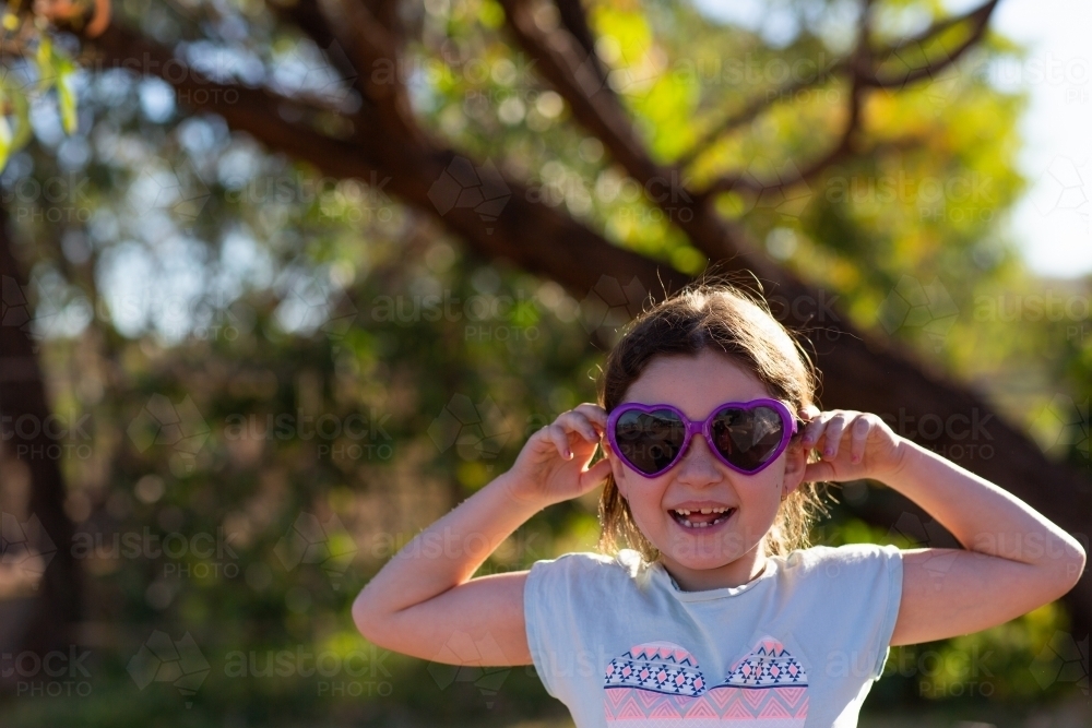 Happy child with gappy teeth and sunglasses - Australian Stock Image