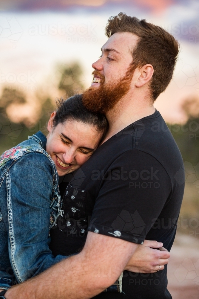 Image of Happy couple hug outside at dusk - Austockphoto