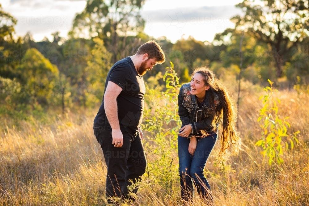 Happy couple laugh together outside in nature - Australian Stock Image