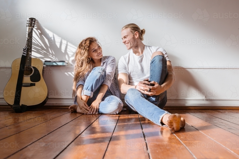 Happy couple smiling at each other in their new apartment - Australian Stock Image