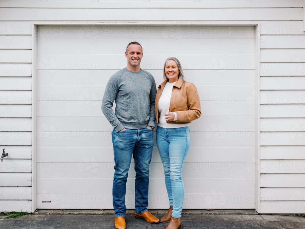 Happy couple stands in the driveway of their new home - Australian Stock Image