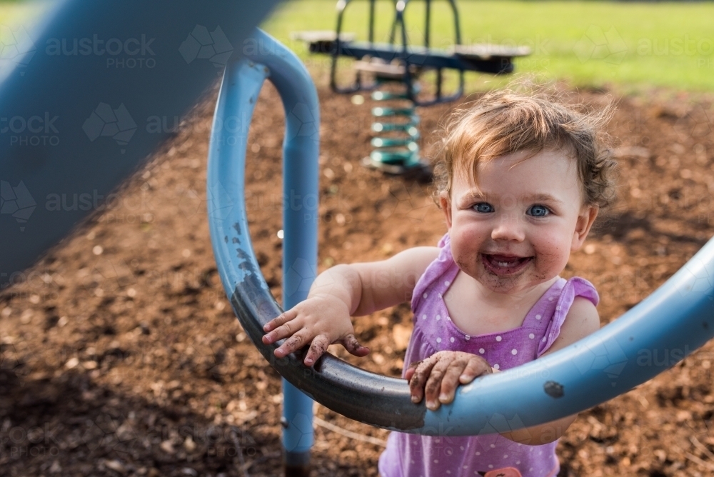 Happy dirty kid playing at the park outdoors - Australian Stock Image