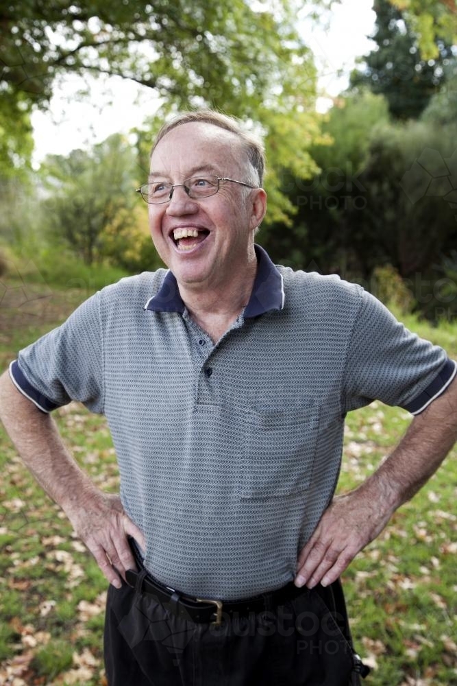 Happy disabled man standing outside with hands on hips - Australian Stock Image