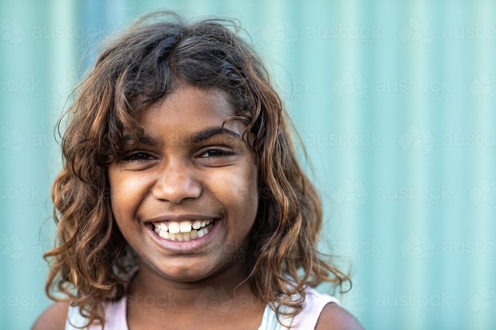 Happy Eight year old girl with curly hair smiling - Australian Stock Image
