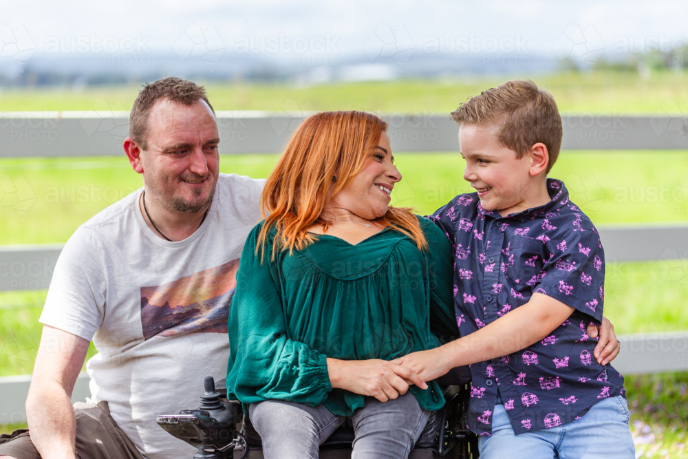 Happy family of three smiling together in countryside mum dad and boy - Australian Stock Image
