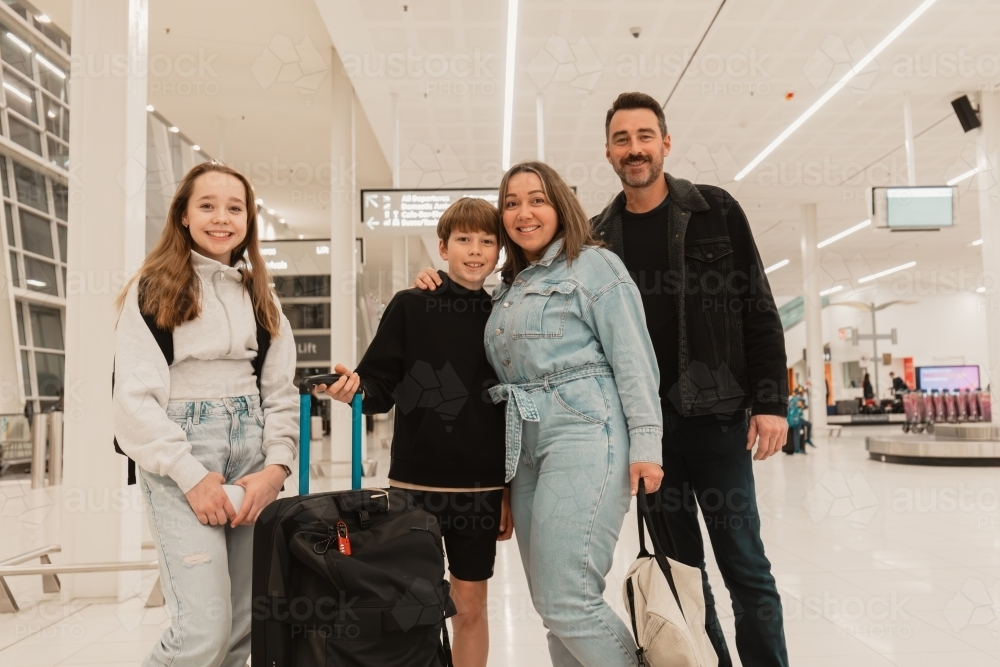 Happy family smiling together at the airport - Australian Stock Image