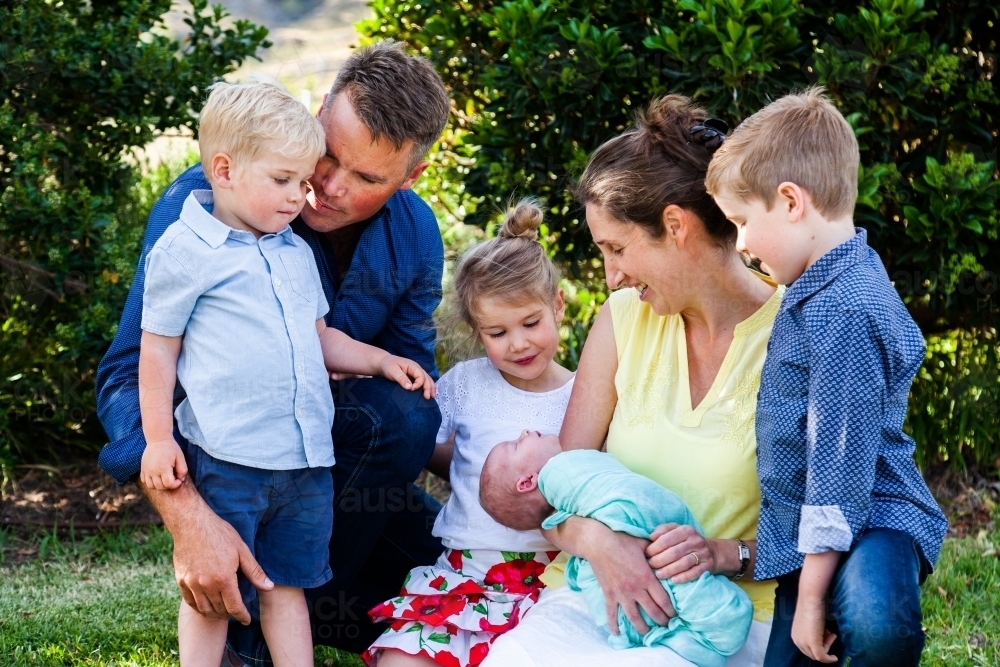Happy family with four young kids all together in garden - Australian Stock Image