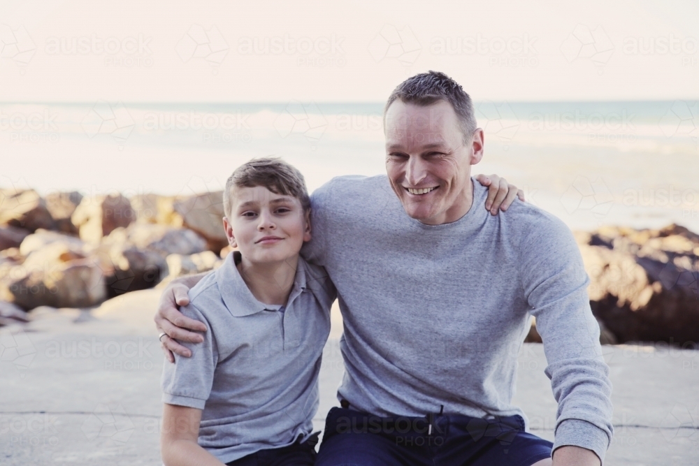 Happy father and teen son on the beach - Australian Stock Image