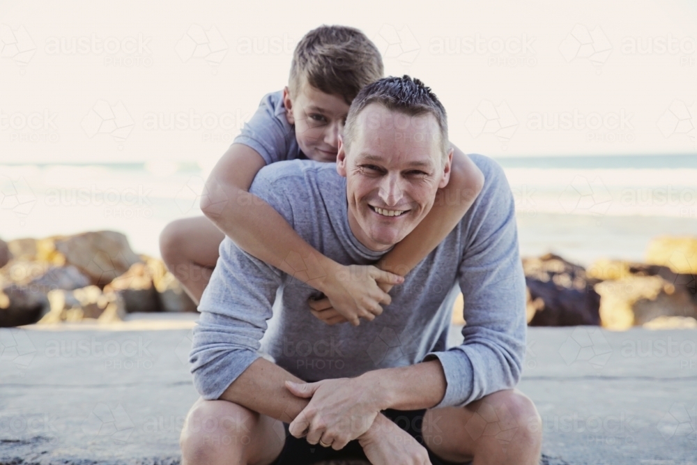Happy father and teen son on the beach - Australian Stock Image