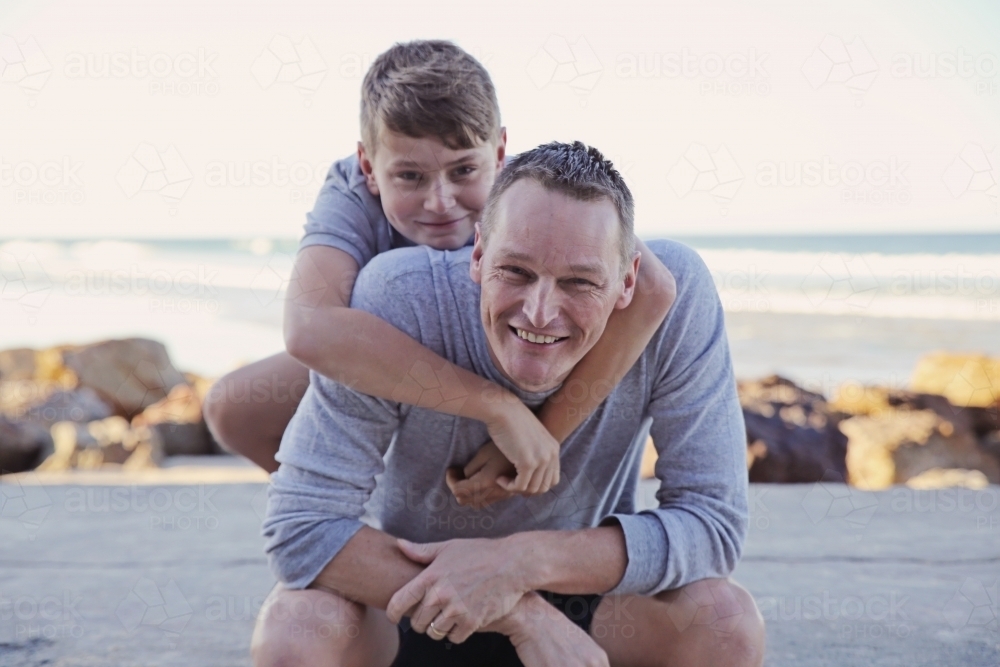 Happy father and teen son on the beach - Australian Stock Image