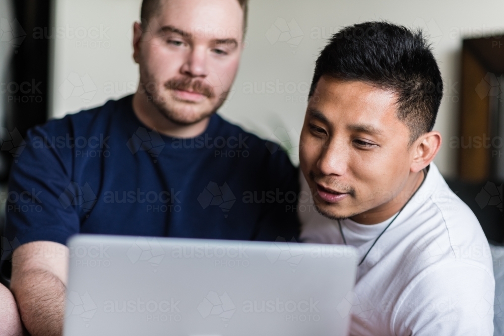 happy gay couple using computer - Australian Stock Image