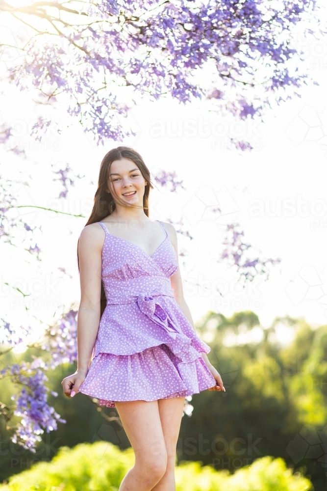Happy girl in a purple dress spinning outside - Australian Stock Image