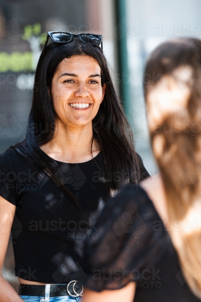 happy indigenous Australian woman chatting with friend - Australian Stock Image