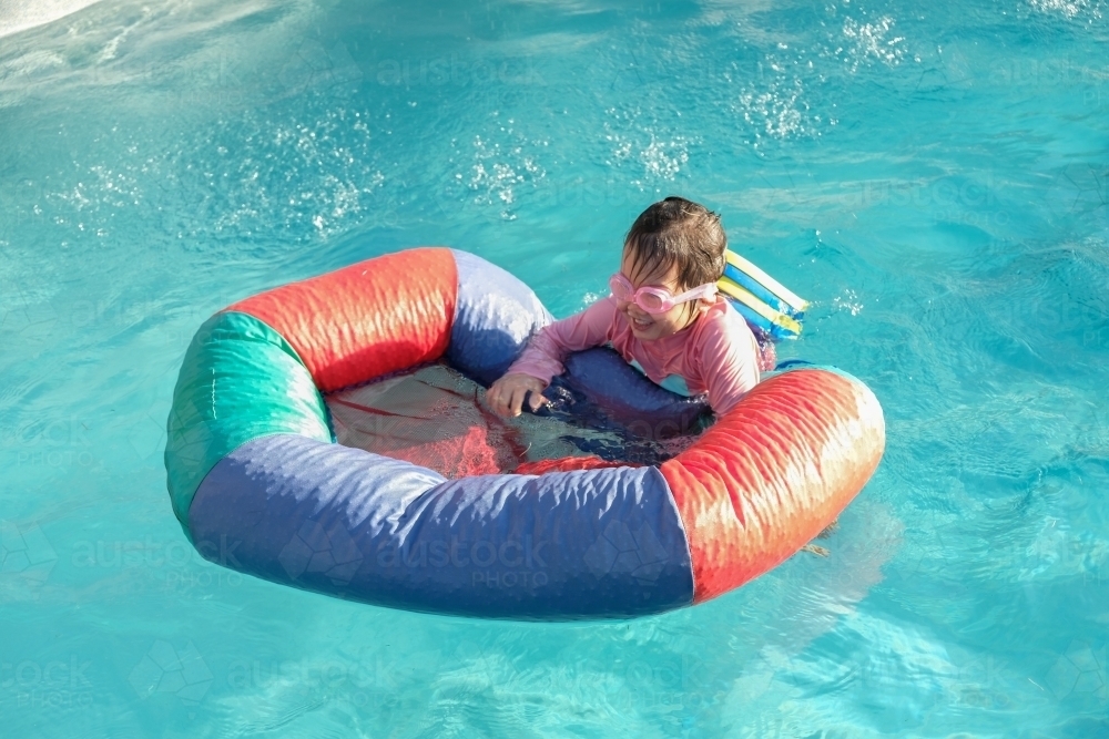 Happy little girl playing in the pool - Australian Stock Image