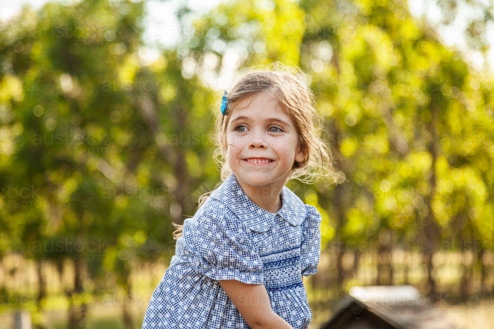 Happy little girl smiling outside - Australian Stock Image