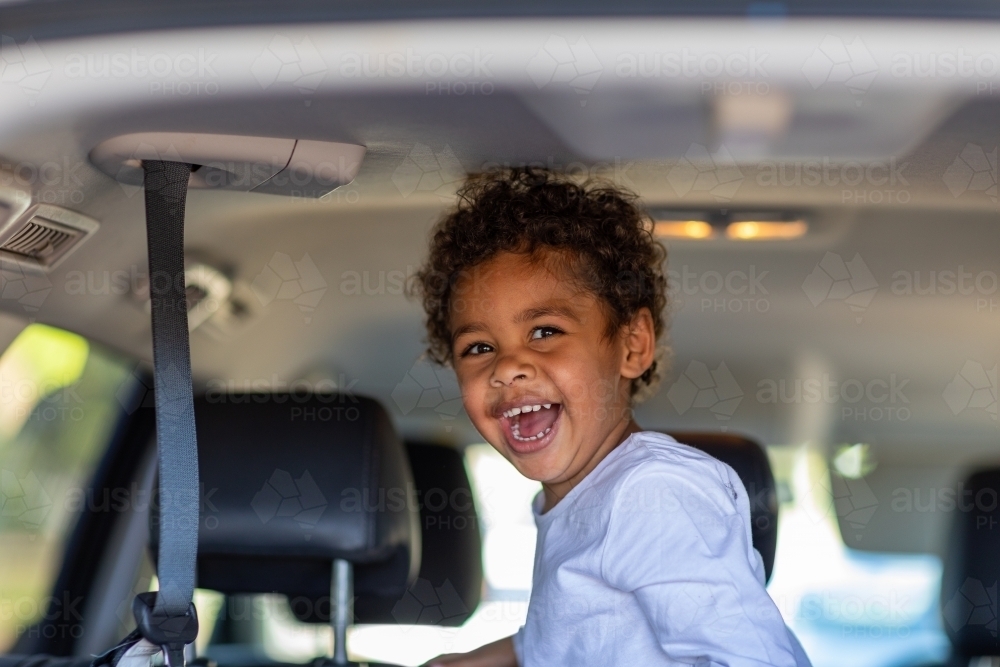happy little kid in back of a van - Australian Stock Image