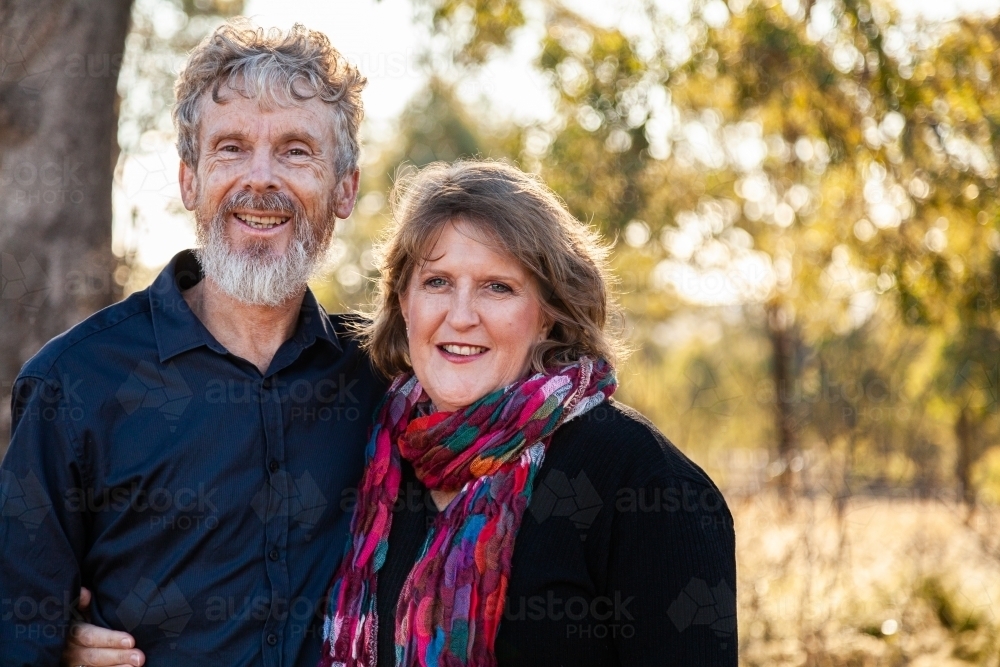 Happy middle aged couple standing together outside - Australian Stock Image