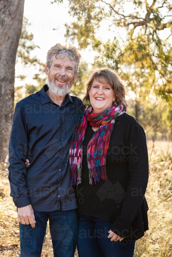 Happy middle aged couple standing together outside - Australian Stock Image