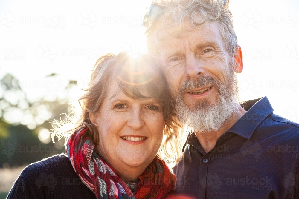 Happy middle aged couple together with sun flare close up - Australian Stock Image