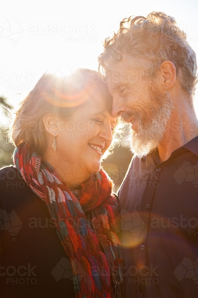 Happy middle aged couple together with sun flare close up - Australian Stock Image