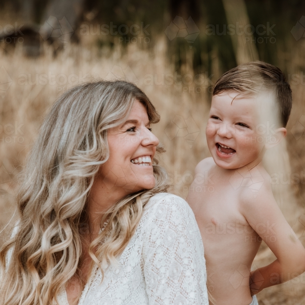 Happy mother and son together in field outside - Australian Stock Image