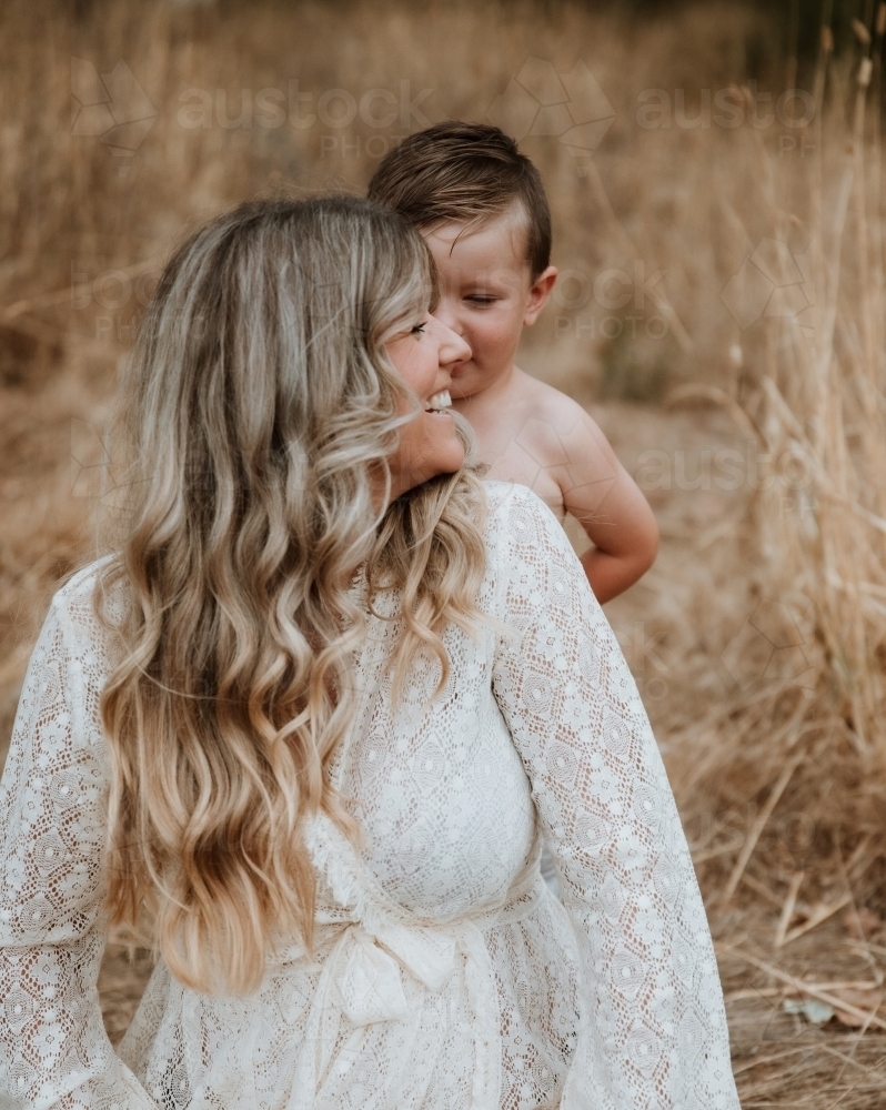 Happy mother and son together in field outside - Australian Stock Image
