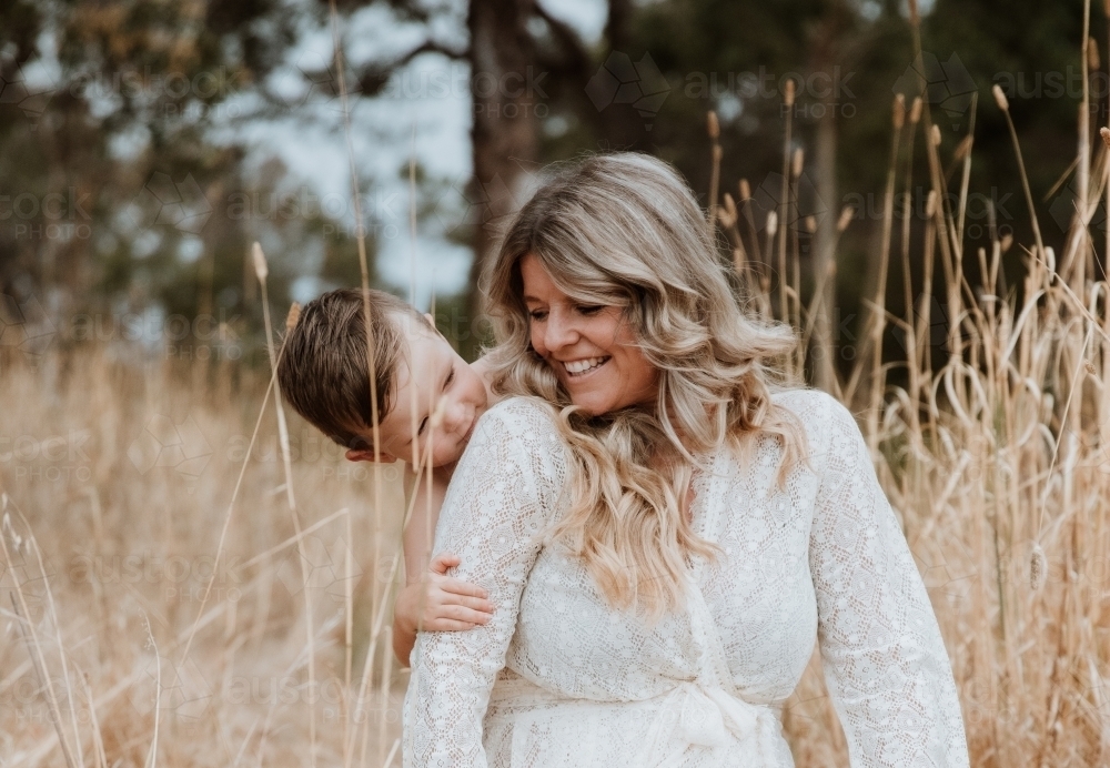 Happy mother and son together in field outside - Australian Stock Image