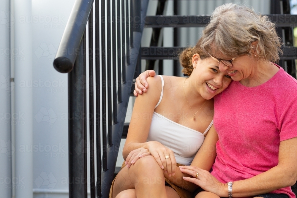 happy mother and teen daughter embracing - Australian Stock Image