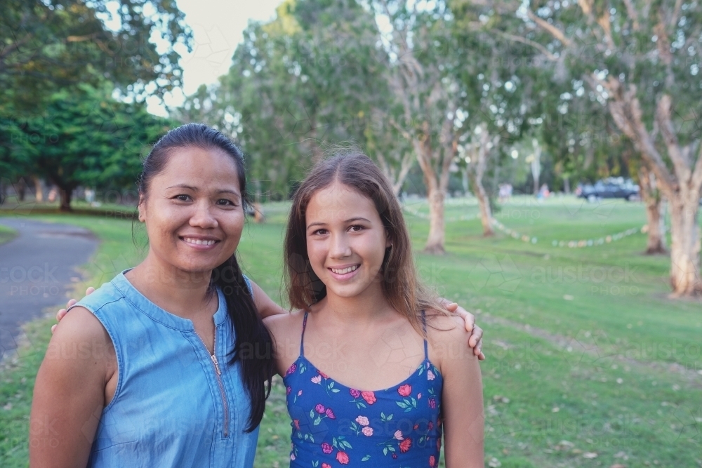 Happy multicultural mother and daughter in the park - Australian Stock Image
