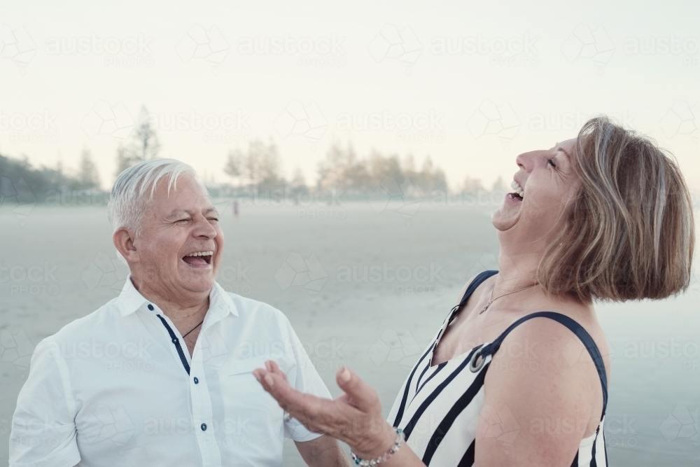 Happy multicultural senior couple on the beach - Australian Stock Image