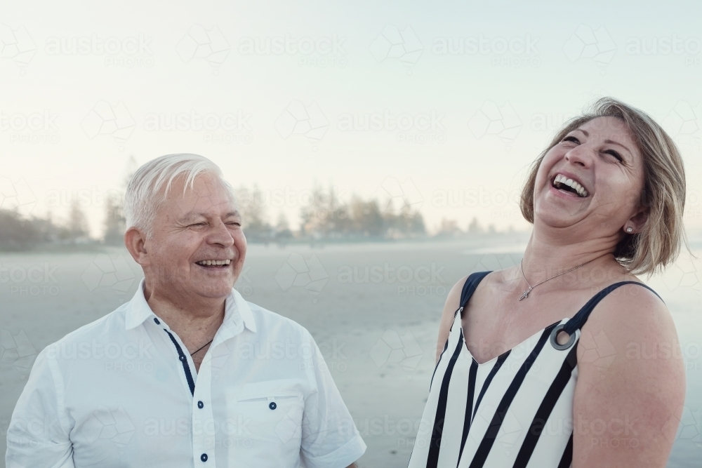 Happy multicultural senior couple on the beach - Australian Stock Image