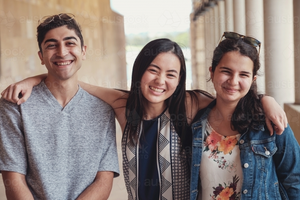 Happy multicultural students in library - Australian Stock Image