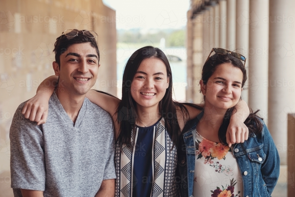 Happy multicultural students in library - Australian Stock Image