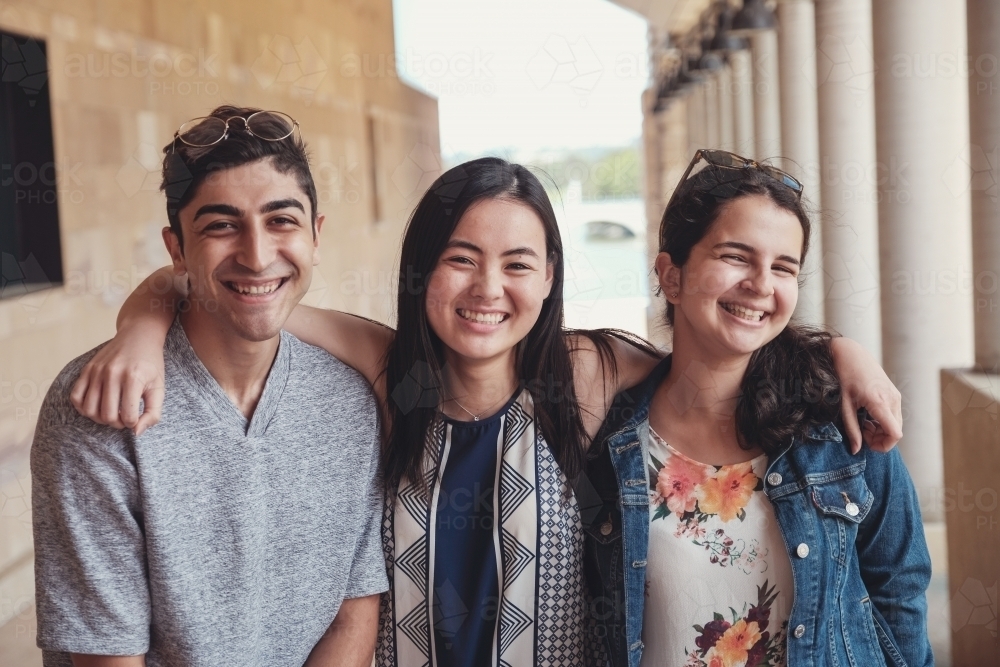 Happy multicultural students in library - Australian Stock Image
