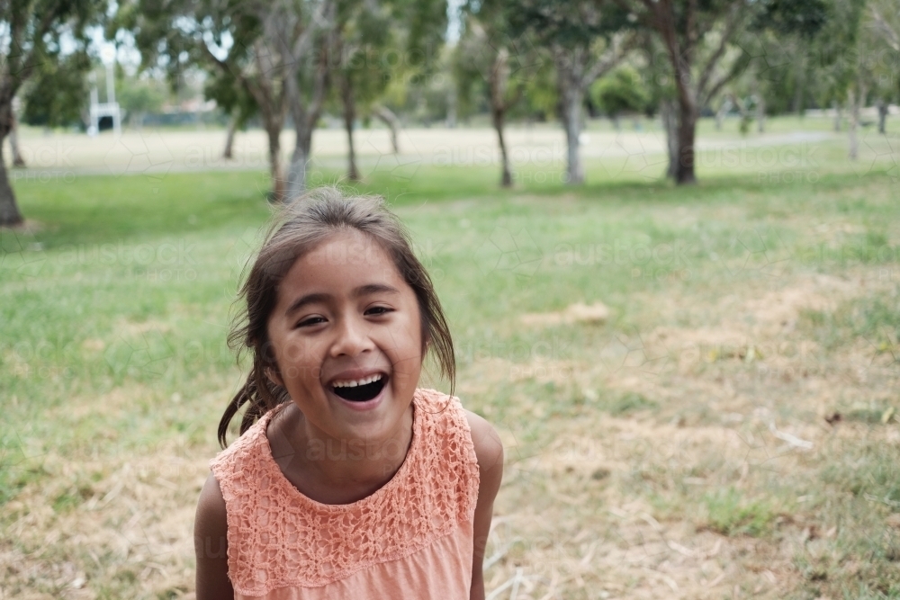 Happy multicultural young girl at park - Australian Stock Image