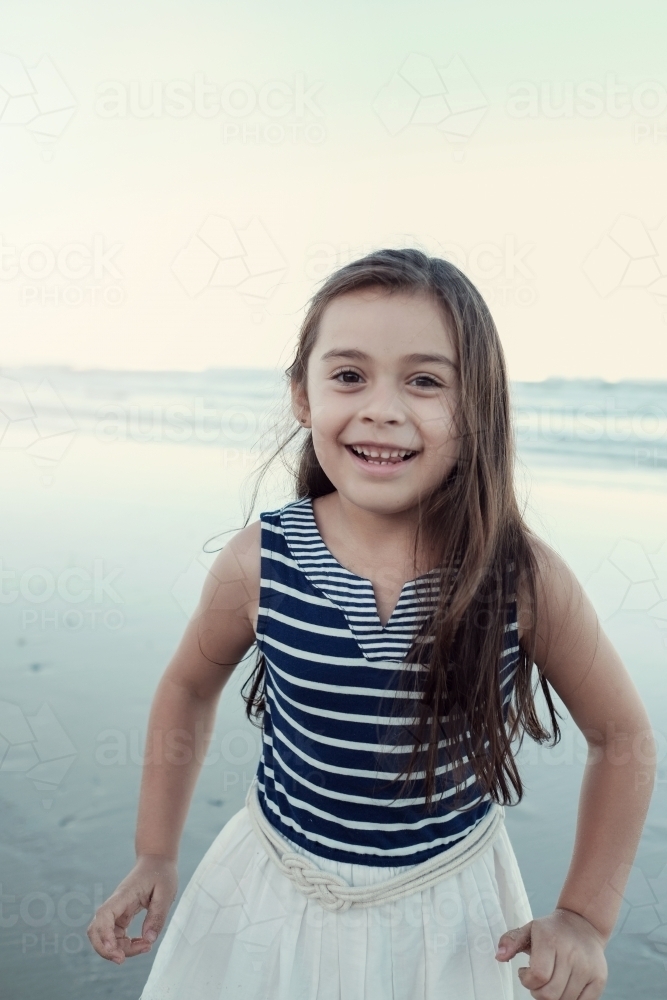 Happy multicultural young little girl on the beach - Australian Stock Image