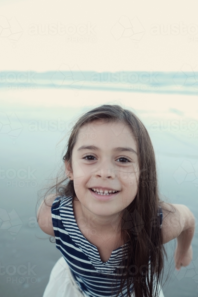 Happy multicultural young little girl on the beach - Australian Stock Image