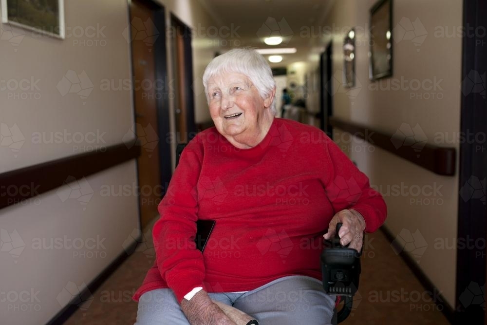Happy nursing home resident sitting in wheelchair - Australian Stock Image