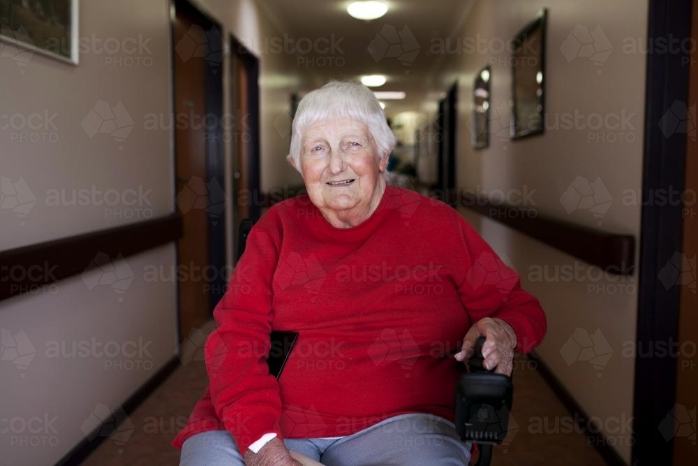 Happy nursing home resident sitting in wheelchair - Australian Stock Image