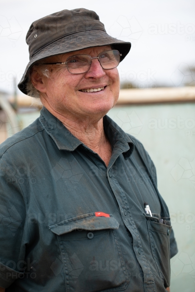 Image of happy older man wearing bucket hat and work clothes - Austockphoto