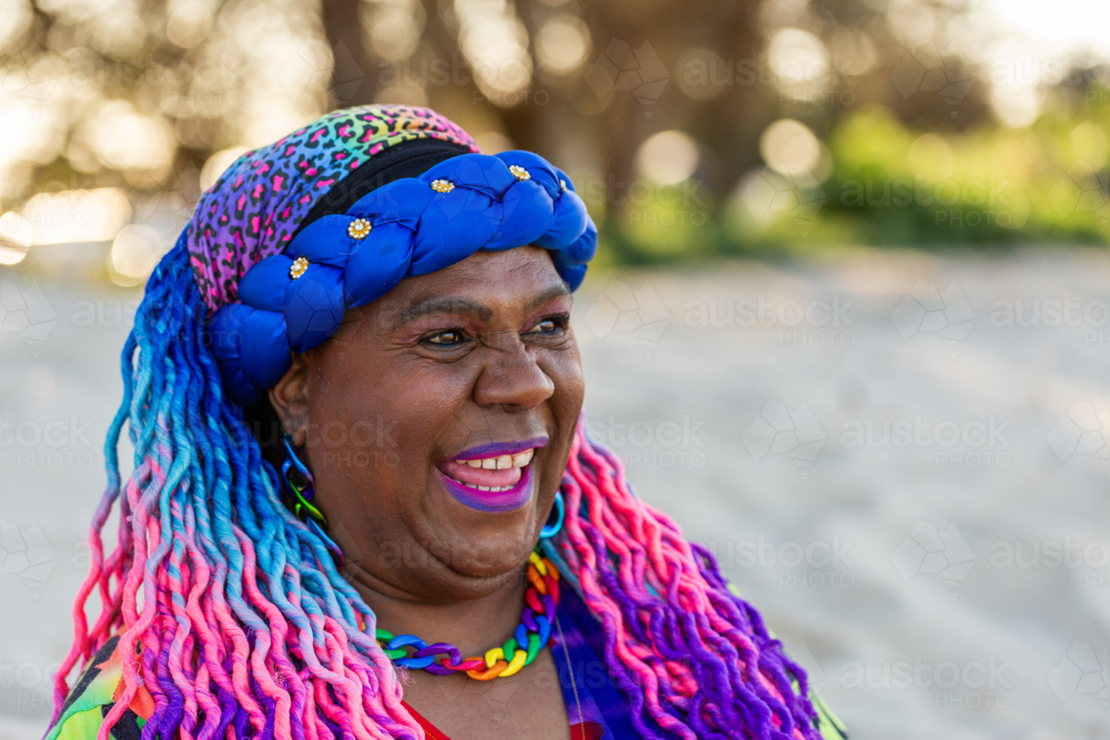 Happy portrait of First Nations Australian Torres Strait Islander woman in her late fifties at beach - Australian Stock Image