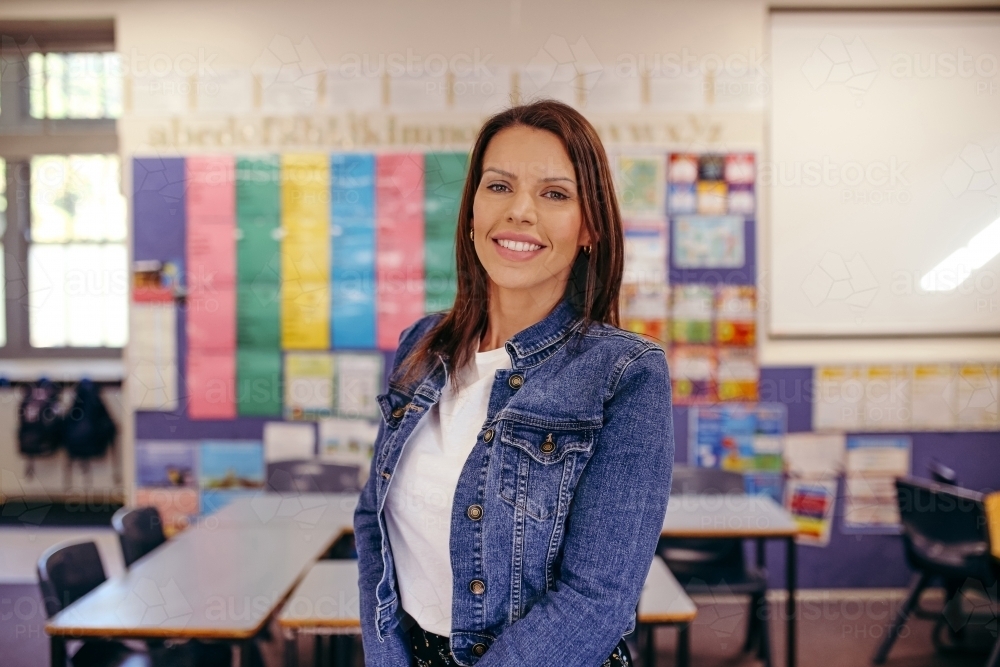 Image of Happy primary school teacher in classroom smiling at camera ...