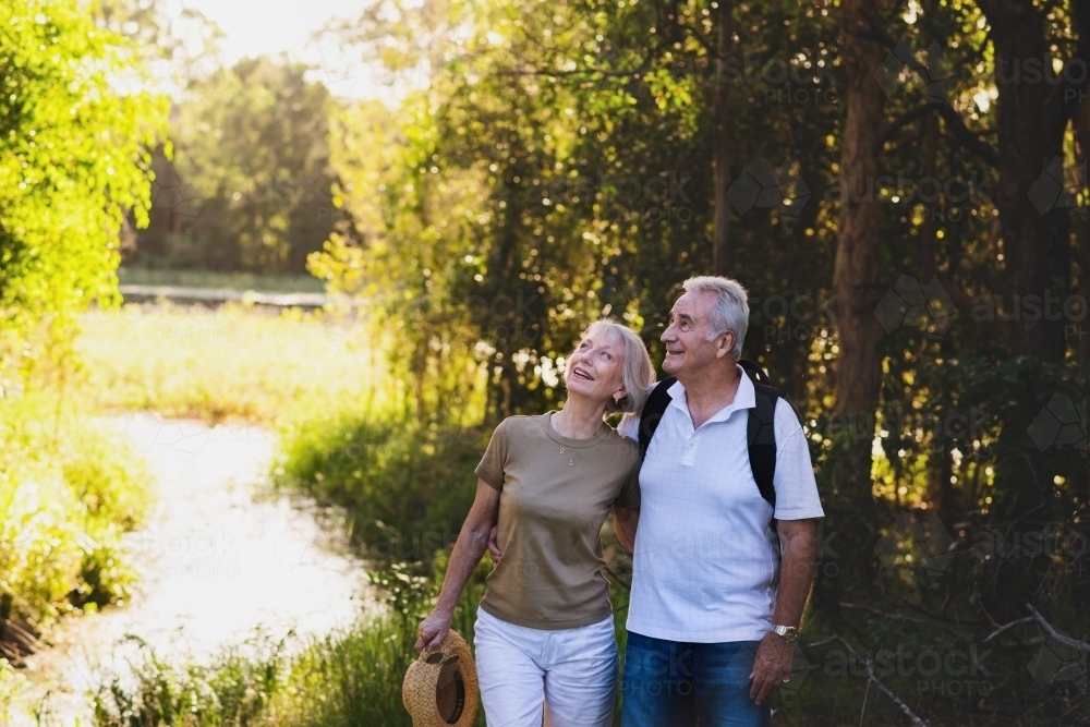 Image of happy senior couple on a nature walk - Austockphoto