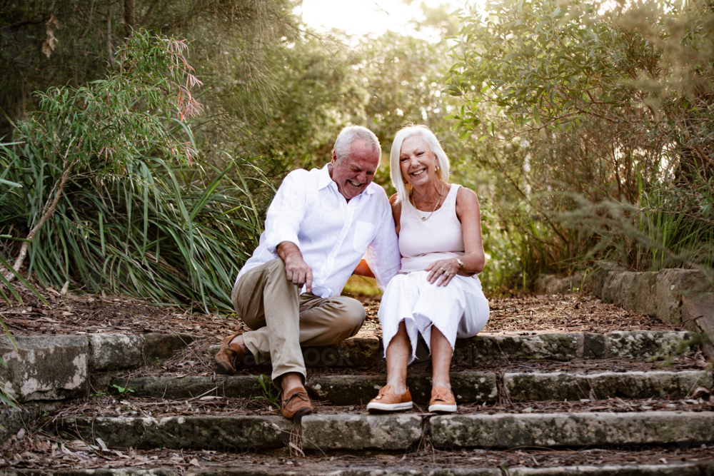 Happy senior couple sitting on a concrete staircase - Australian Stock Image