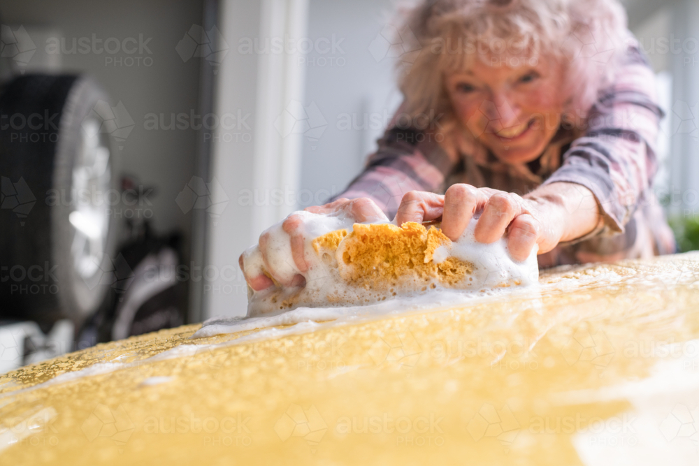 happy senior woman washing her car - Australian Stock Image