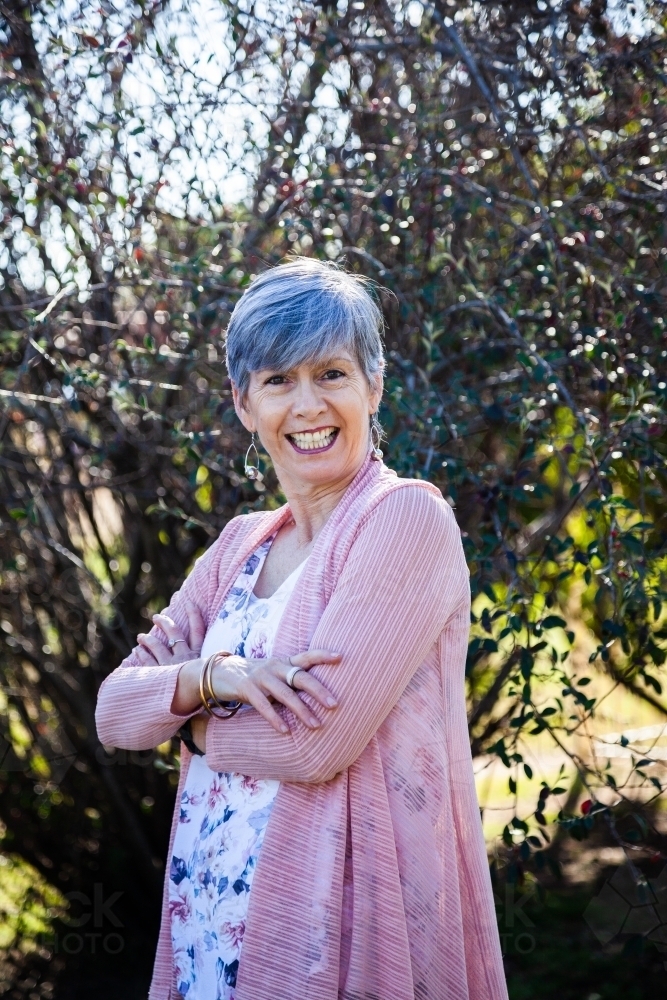 Happy senior woman with a big grin outside in the garden - Australian Stock Image